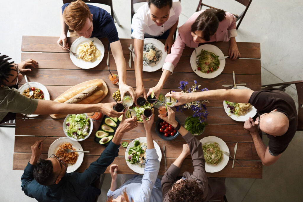 Group of people celebrating over Italian food and drinks.